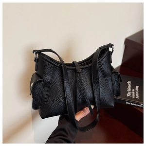 Detail of minimalist black lychee grain leather underarm bag with side flap pockets