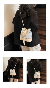 Detail of light blue plaid bucket bag with cartoon bear patterns and leather drawstrings