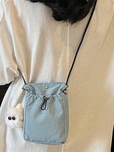 Light blue nylon crossbody phone bag with drawstring and cute white monster plush pendant