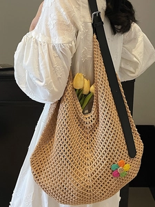 Chic beige woven crochet tote bag with colorful floral patterns and black leather straps