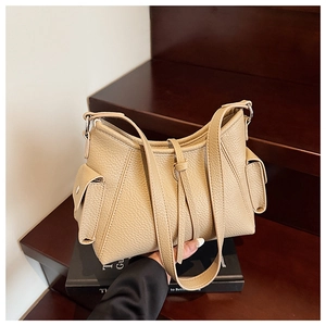 Detailed close-up of khaki pebbled leather shoulder bag on vintage wooden steps