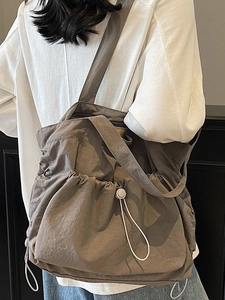 Large commuter tote bag in dark khaki nylon with adjustable drawstring side and wide strap