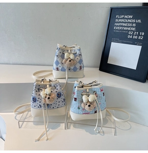 Detailed shot of fabric bucket bags with floral patterns and cute teddy bear charms
