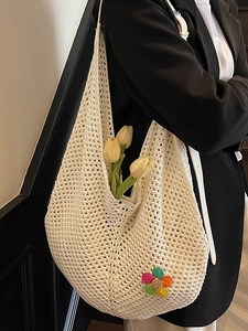Chic cream woven crochet tote bag with colorful floral patches for beach and summer travel