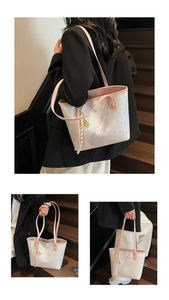 Detailed view of white geometric print tote bag with pink straps and tassel charm