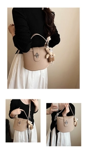 Detailed view of beige pebbled leather shoulder bag with a cute plush bear charm
