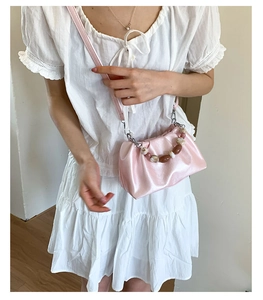 Detail view of pink pleated cloud bag with elegant beaded handle and leather strap