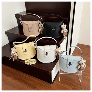 Detailed close-up showing five color variants of leather bags with bear charms