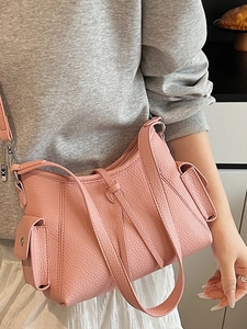 Pink lychee texture leather shoulder bag with side pockets on casual model outfit