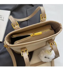 Detail of golden metal zipper and smooth sliding hardware on two-tone bucket bag