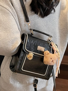 Zaino vintage in ecopelle nera con bordo di perle e ciondolo a forma di orsetto