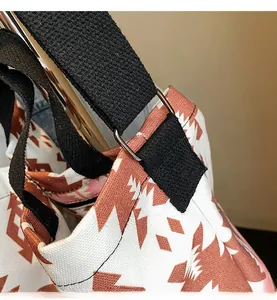 Close-up of reinforced shoulder strap stitching and metal ring on printed canvas tote