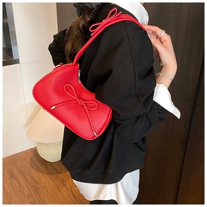 Close-up of a red litchi texture dumpling bag featuring stylish bow tie details