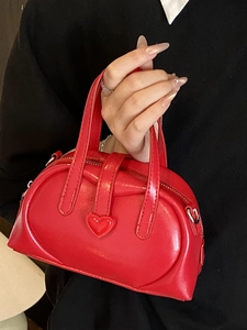 Minimalist red heart dumpling handbag in glossy finish with round top handles and zip