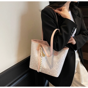 Detail of beige tote bag featuring geometric floral prints and pink leather shoulder straps