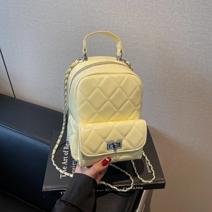 Detailed macro view of yellow quilted leather texture with silver metal chain strap