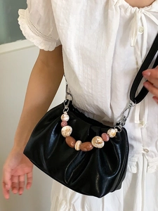 Fashionable black pleated cloud bucket bag with beaded handle and leather crossbody strap