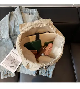 Internal view of the beige nylon backpack showing large capacity for tablet and umbrella
