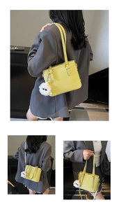 Detail of yellow bucket bag with plush sheep charm and detachable shoulder strap