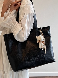 Large black commute tote bag with vintage texture and plush bear charm decoration