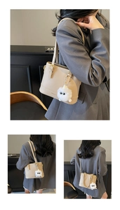 Detailed view of beige PU leather bucket bag featuring gold hardware and plush charm