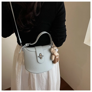 Detail of mint green lychee pattern shoulder bag with a cute bear plush keychain