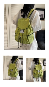 Detail view of water-resistant green nylon backpack with drawstring and woven label
