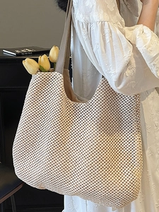 Large beige hand-woven straw tote bag with honeycomb pattern and brown leather strap