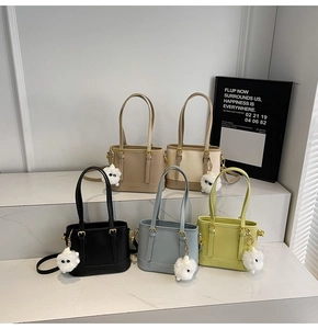 Detailed view of bucket bags in five colors with cute plush monster charms and metal buckles
