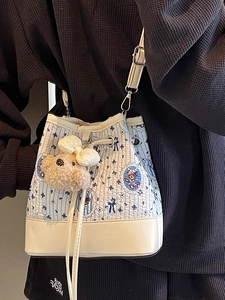Blue and white quilted bucket bag with cartoon bear prints and plush pendant for women