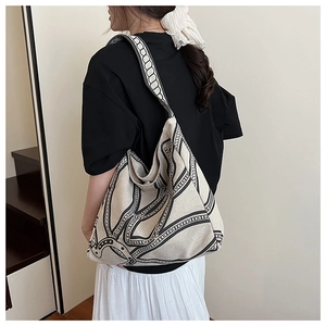 Detail of printed canvas tote bag featuring bold black geometric chain patterns