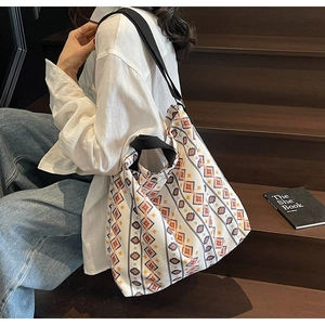 Detail view of ethnic geometric pattern on large canvas tote bag with black shoulder strap