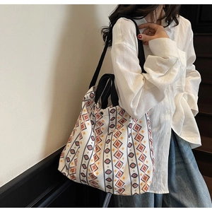 Lifestyle shot of large canvas tote bag with geometric print on a wooden staircase