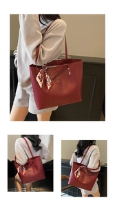 Detail der roten Tragetasche mit bedrucktem Seidenschal und Tasche mit Logo-Prägung