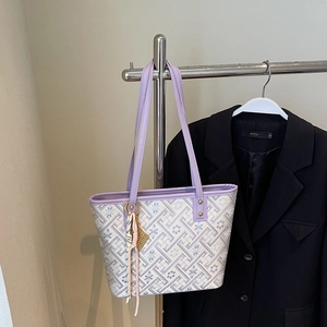 Close-up of purple printed tote bag with geometric patterns and leather handles