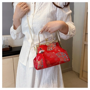 Detailed embroidery of blue fans and red tassels on a vintage silk evening bag
