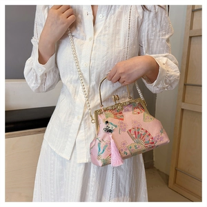 Detail of pink embroidered silk handbag with pearl strap and elegant tassel accessory