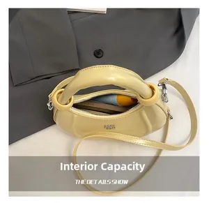 Top-down view of the crescent bag's inner capacity showing phone and lipstick