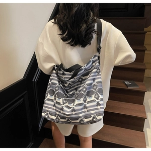 Detailed view of canvas tote bag with blue geometric pattern and adjustable shoulder strap