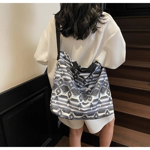 Detail of a large capacity canvas tote bag with geometric print and black straps