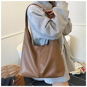 Detail of a brown lychee pattern leather tote bag showing large capacity and strap