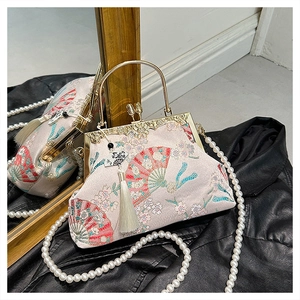 Detail of fan-shaped embroidery on silk bag with pearl strap and white silk tassel