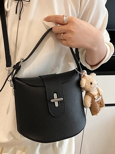 Minimalist black lychee leather bucket bag with silver twist lock and cute bear charm