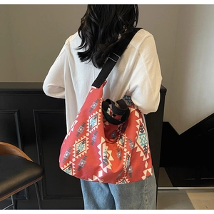 Detail of red geometric canvas tote bag with wide strap and bohemian diamond pattern