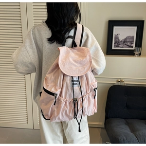 Detailed back view of a pink nylon backpack featuring drawstring closure and side zip pockets