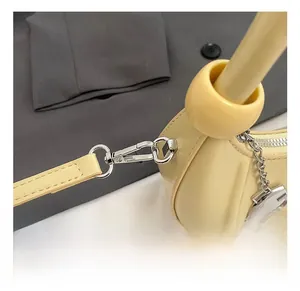 Detailed view of yellow leather crescent bag with silver hook and G-letter pendant