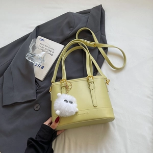 Detail of lime yellow bucket bag with branding, gold hardware and furry charm