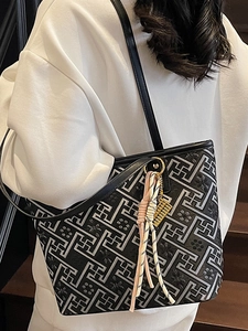 Fashionable black tote bag with geometric maze pattern and golden abacus charm