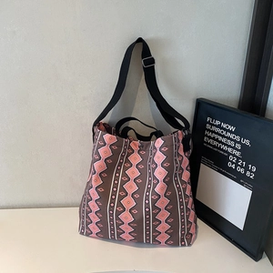 Detailed close-up of a large geometric canvas tote bag with adjustable shoulder straps
