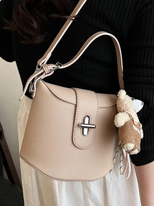 Chic beige saddle shoulder bag with litchi texture and cute bear charm pendant